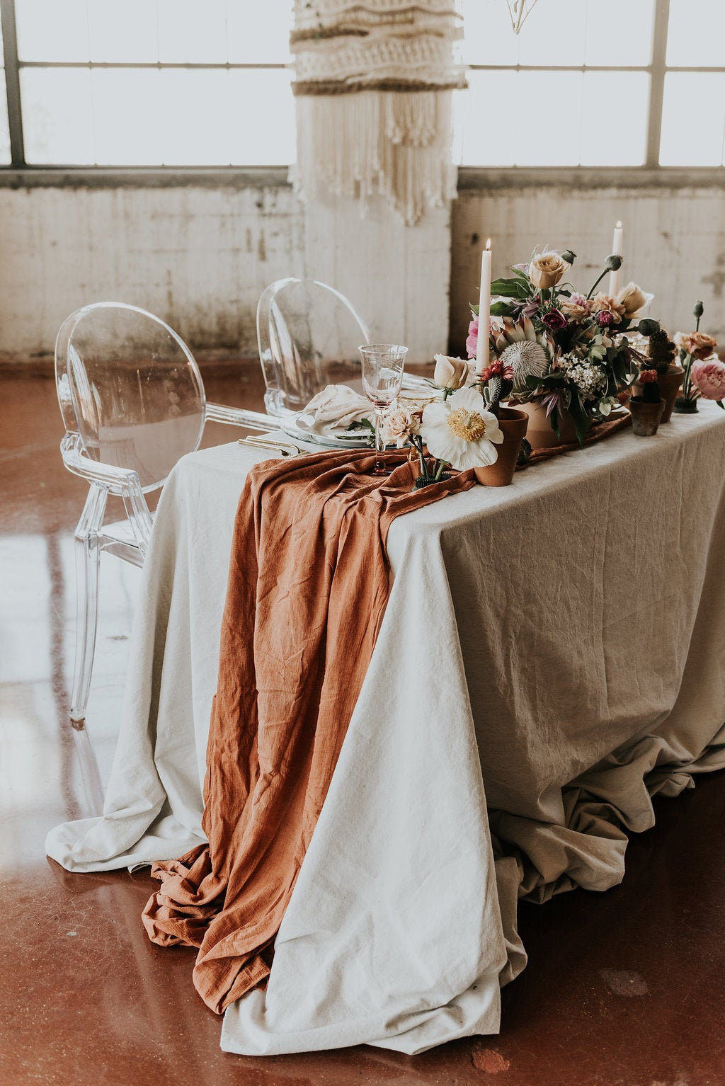 rust orange textured linens table runner with floral arrangement