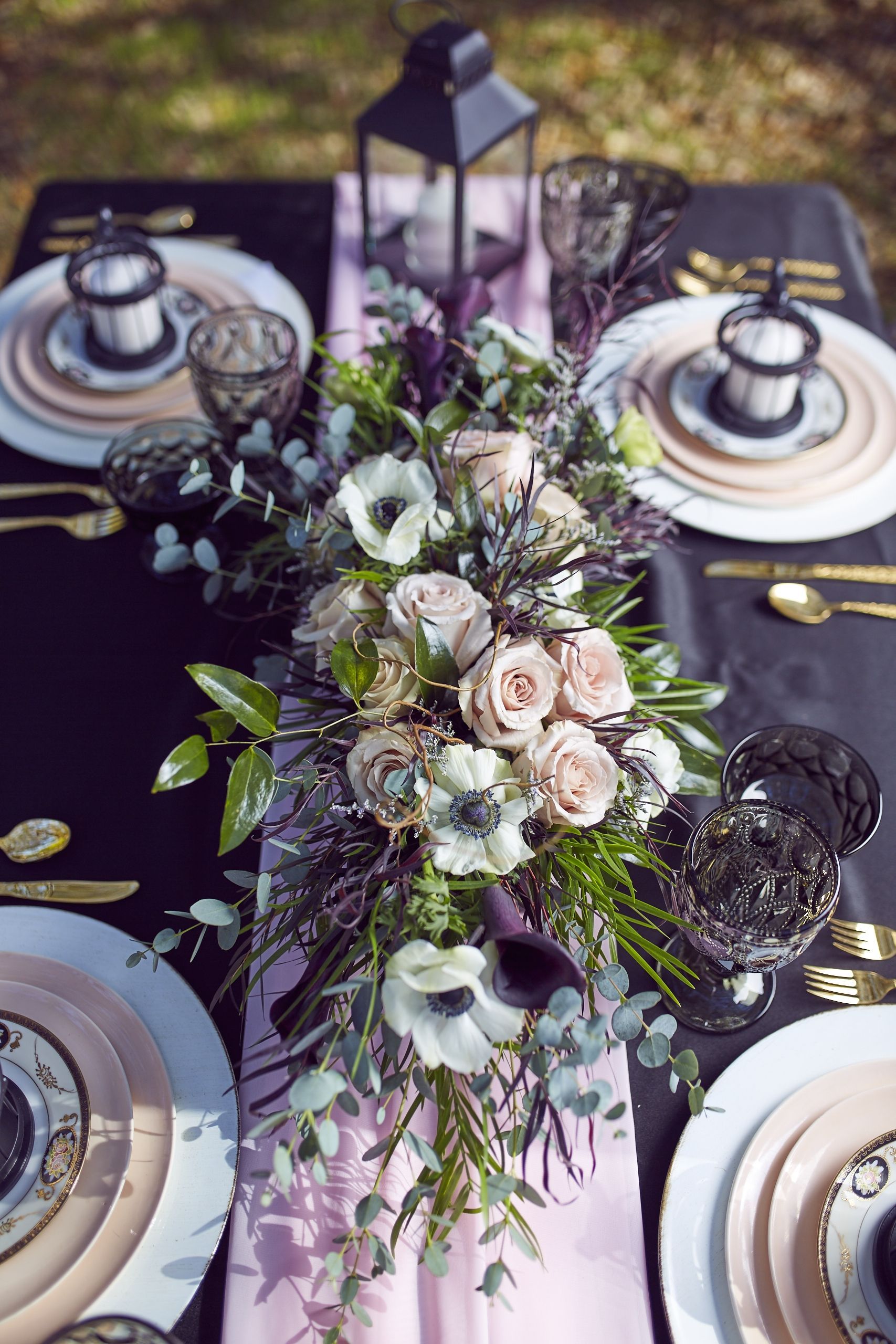 Purple floral arrangement with wedding dinner table setting