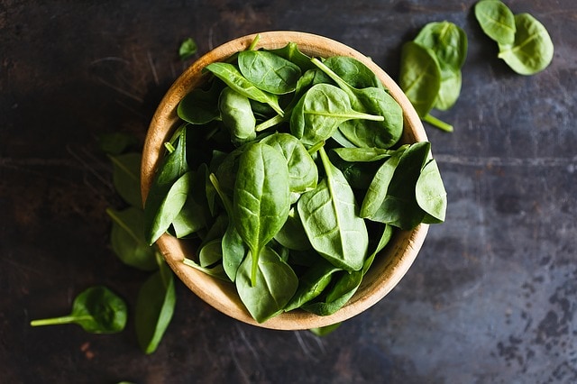 top view of basil leaves in a wooden bowl