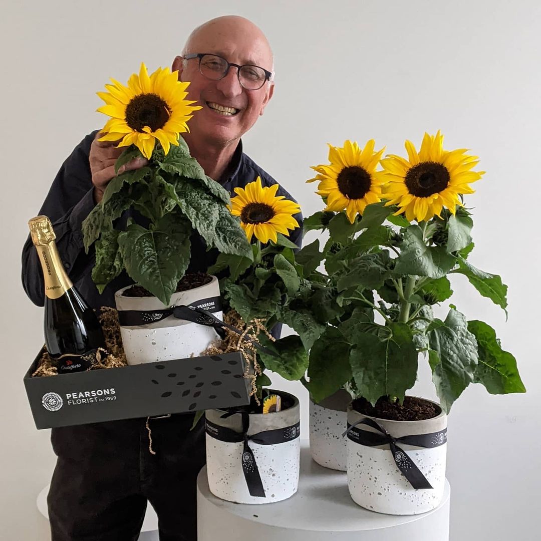 gentleman with sunflower plants