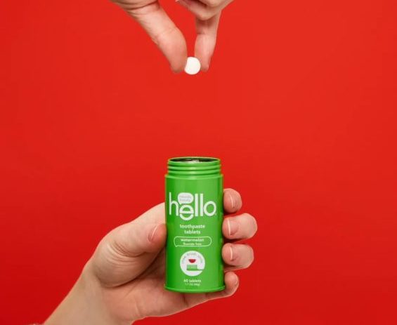 toothpaste tablets hand dropping hello tablets into green bottl