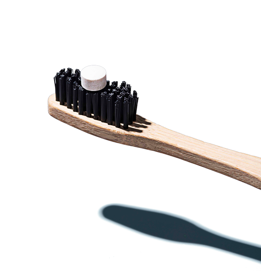bite toothpaste bit on a wooden toothbrush